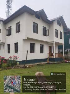 a white house with a sign in front of it at Visiting Villa in Srinagar