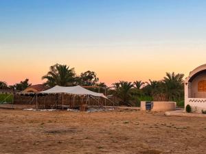 a tent is set up in front of a mosque at Siwa Nostalgia Ecolodge in Siwa