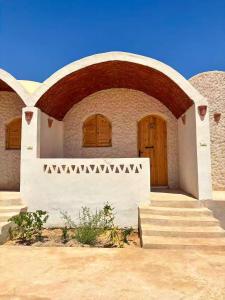 a building with a wooden door and some stairs at Siwa Nostalgia Ecolodge in Siwa