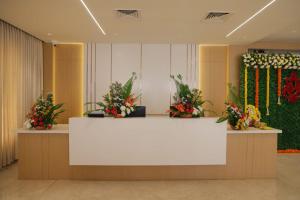 a lobby with a white counter with flowers on it at MOKSH SERENe in Shrīnagar
