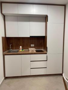 a kitchen with white cabinets and a sink at Sunny Coast in Dobra Voda