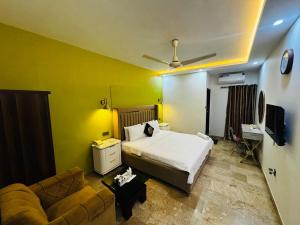 a bedroom with a bed and a couch at Seaview Lodge Guest House in Karachi