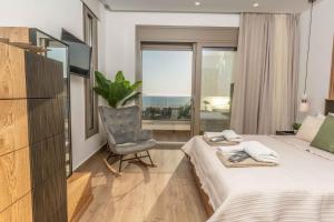 a bedroom with a bed and a chair and a window at 3 Muses Luxury Villas in Kalamaki +109 photos
