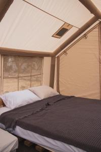 a bed in the middle of a tent at Mosh Achziv Beach in Gesher HaZiw +18 photos