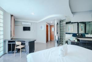 a bedroom with a bed and a desk and a kitchen at XXCASA Sukhumvit 39 คาซ่า สุขุมวิท 39 BTS ทองหล่อ in Klong Toi