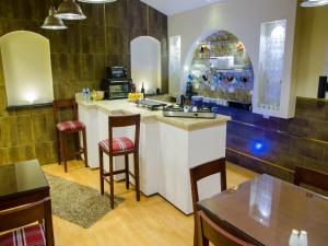 a kitchen with a counter and some chairs and tables at Grand Agor Hotel Cairo in Cairo