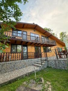 a large wooden house with a large balcony at Complex Turistic Hor'A in Slănic