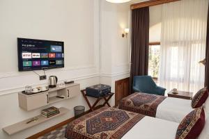 a hotel room with two beds and a flat screen tv at Epicenter Hotel Baku in Baku