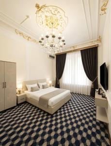 a bedroom with a large bed and a chandelier at Epicenter Hotel Baku in Baku