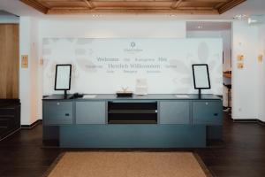 a desk with two monitors on it in front of a screen at AlpinLodges Kühtai in Kühtai