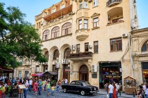 an old car parked in front of a building at Epicenter Hotel Baku in Baku