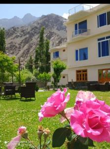 two pink roses in front of a house at Relax in in Skardu