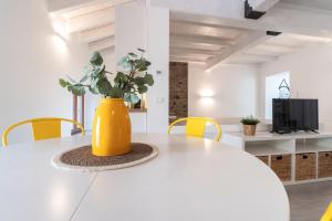 a white table with a yellow vase on it at L'appartamento giallo zafferano in Fanano +7 photos
