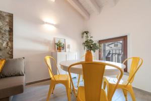 a dining room with a table and yellow chairs at L'appartamento giallo zafferano in Fanano