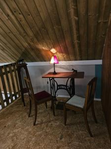 a table and two chairs with a lamp on it at Les Marronniers Roses in Châteaulin