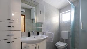 a bathroom with a sink and a toilet and a mirror at House Antonia by Villas Guide in Opuzen +15 photos