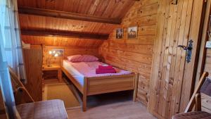 a small room with a bed in a wooden cabin at Feriennest Buendorf in Dahlenburg