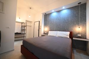 a bedroom with a large bed with a black wall at Brindisi Airport Rooms in Brindisi