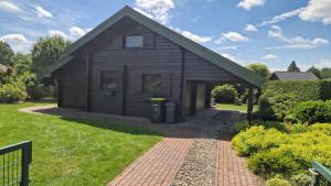 a small wooden house with a brick driveway at Feriennest Buendorf in Dahlenburg