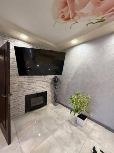 a living room with a fireplace and a flat screen tv at Villa in Uman