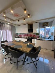 a kitchen with a wooden table and black chairs at Villa in Uman