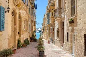 an alley between buildings with a view of the water at Dar Vitorja in Senglea