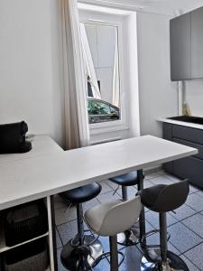 a kitchen with a white table and four stools at Casa Dax - Centre - Moderne - Linge inclus in Dax