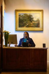 a woman sitting at a desk with a laptop at Palm House Boutique Hotel and Spa in Cape Town +199 photos