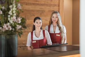 two girls sitting at a table with a laptop at Resort Das Achental in Grassau +47 photos