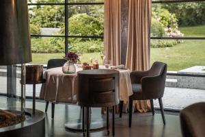 a dining room with a table and chairs and a window at Resort Das Achental in Grassau