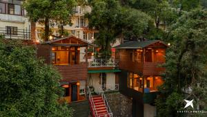 a group of houses in a city with trees at Zostel Homes Mussoorie, Mall Road in Mussoorie