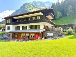 a large house on top of a green hill at Landhaus Spielmannsau in Oberstdorf