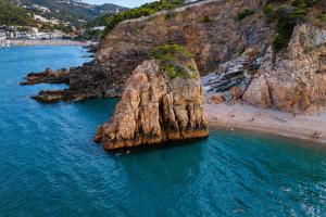 a rock formation in the water next to a beach at Kampaoh Costa Brava in Pals