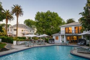 a swimming pool in front of a house at Palm House Boutique Hotel and Spa in Cape Town