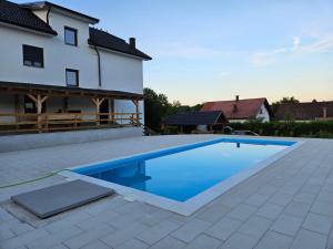 a swimming pool in front of a house at Plitvice House Lina in Rakovica