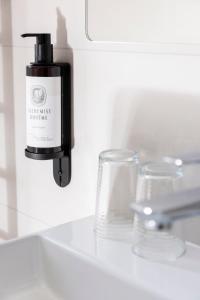 a bottle of soap on a sink next to a glass at Hotel Lunik in Prague +32 photos