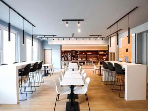 a dining room with white tables and chairs at B&B HOTEL Wien-Heiligenstadt in Vienna
