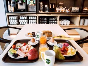 a tray of food on a table with breakfast foods at B&B HOTEL Wien-Heiligenstadt in Vienna
