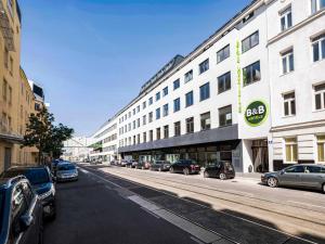 a street with cars parked in front of a building at B&B HOTEL Wien-Heiligenstadt in Vienna