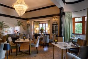 a restaurant with tables and chairs and a chandelier at Palm House Boutique Hotel and Spa in Cape Town