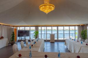 a large room with tables and chairs and a large window at Sonesta Nouba Hotel Aswan in Aswan +119 photos