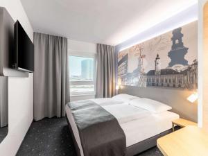 a hotel room with a bed and a large window at B&B HOTEL St-Pölten in Sankt Pölten