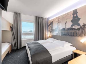 a hotel room with a bed and a large window at B&B HOTEL St-Pölten in Sankt Pölten