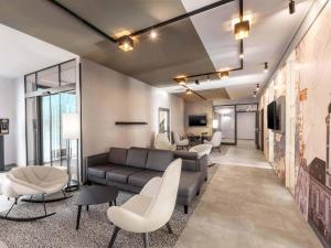a living room with a gray couch and chairs at B&B HOTEL St-Pölten in Sankt Pölten +22 photos