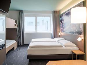 a hotel room with two beds and a window at B&B HOTEL Klagenfurt-City in Klagenfurt