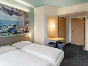 a hotel room with a bed and a desk at B&B HOTEL Klagenfurt-City in Klagenfurt +23 photos