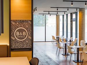 a restaurant with tables and chairs and a sign that reads bc b hotel at B&B HOTEL Klagenfurt-City in Klagenfurt