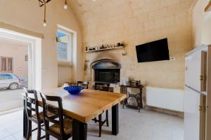 a dining room with a wooden table and a fireplace at Dimora storica Jolanda a Uggiano in Uggiano la Chiesa