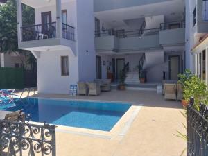a villa with a swimming pool in front of a house at London House Hotel in Kemer