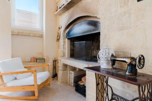 a kitchen with a stone fireplace with a counter with a mixer at Dimora storica Jolanda a Uggiano in Uggiano la Chiesa